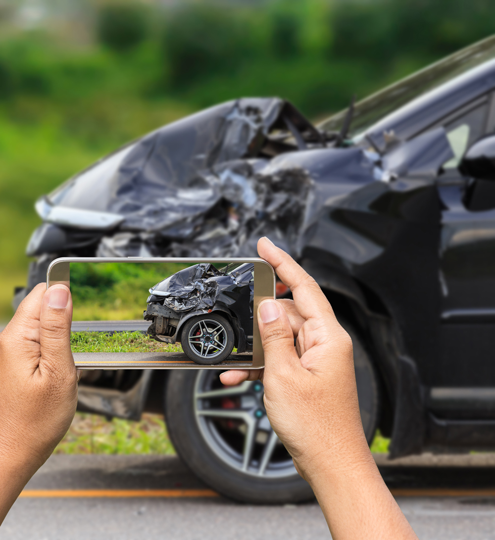 Person taking picture of car after accident