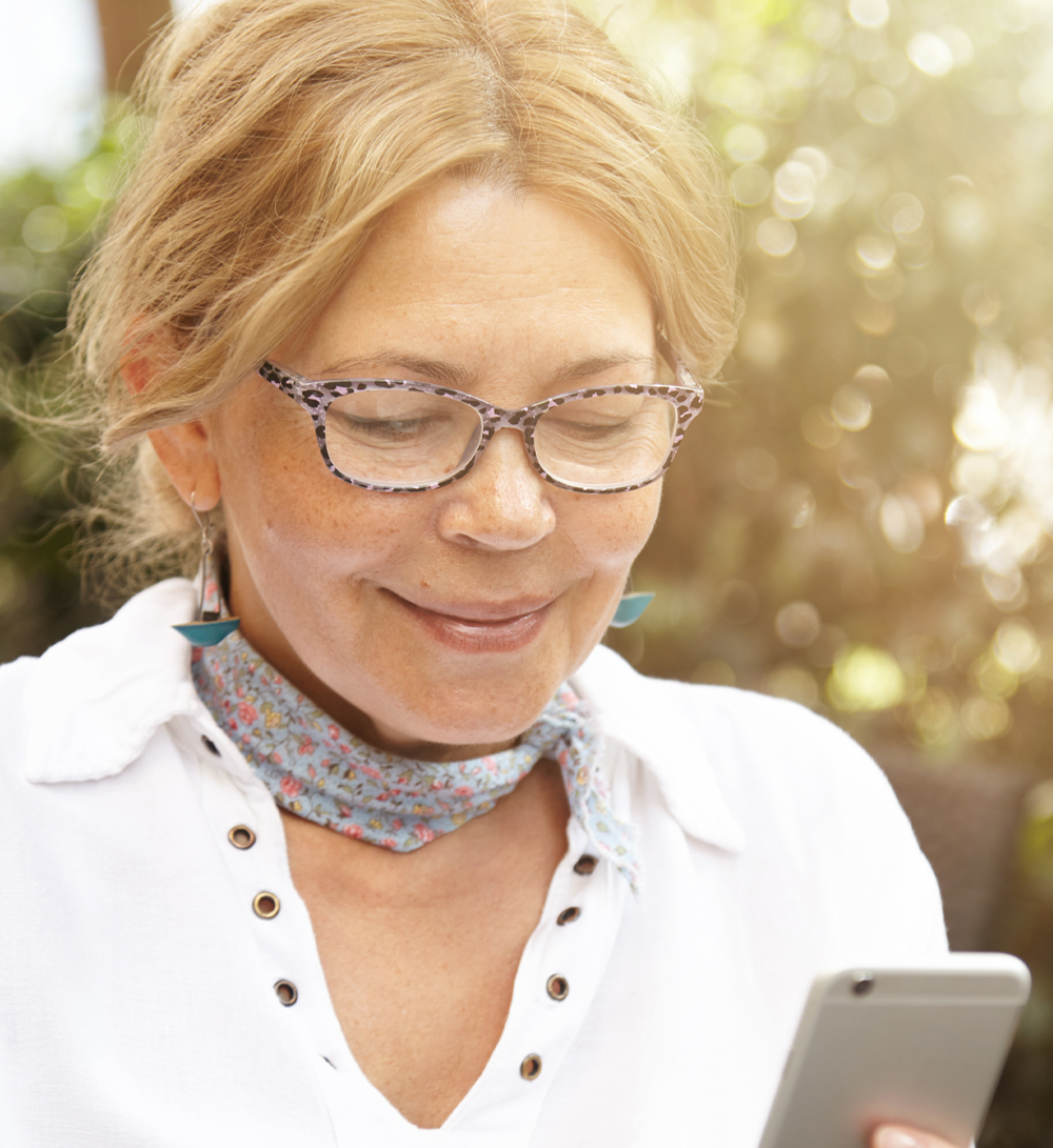 Slightly smiling woman looking at her phone screen