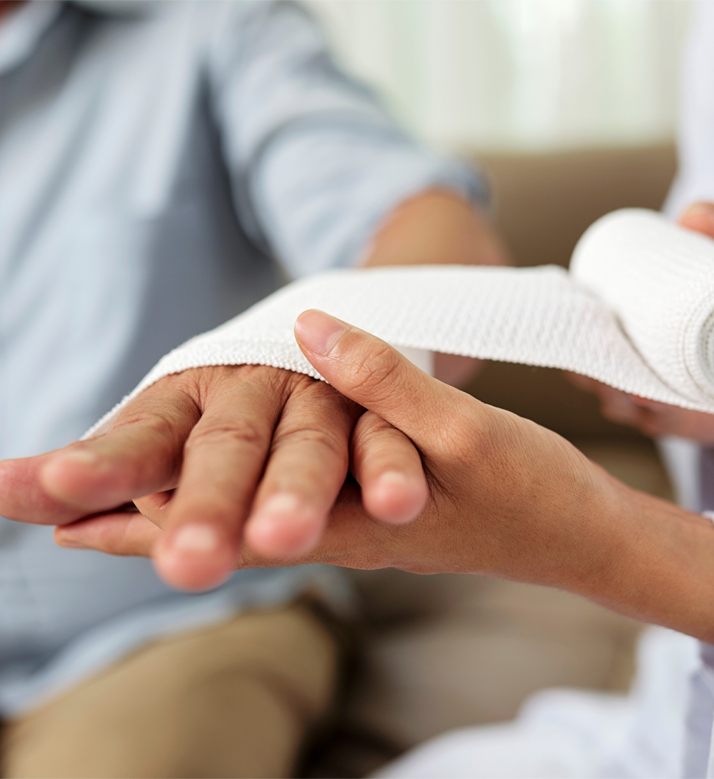 Healthcare professional wrapping an injured worker's wrist