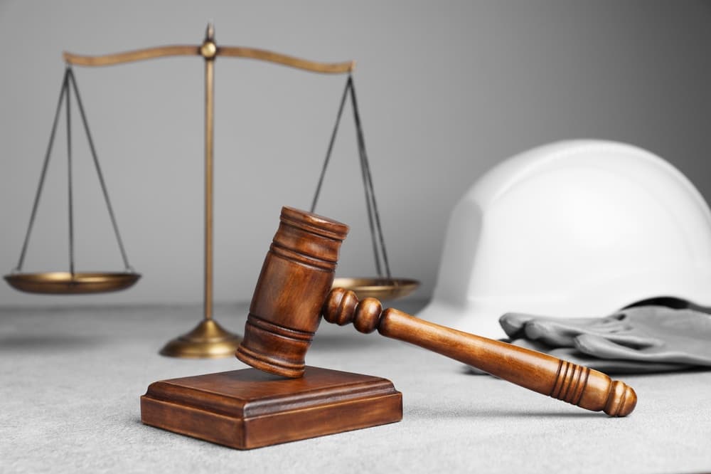 Construction accident attorney symbolized by a gavel, justice scales, and safety helmet representing worker injury claims.