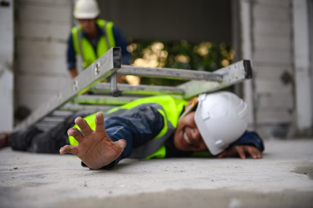 Construction worker injured after falling from a ladder at a job site while wearing safety gear