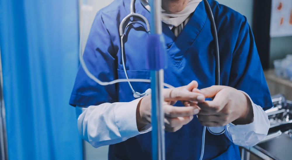 Close-up of nurse administering medication through IV to patient