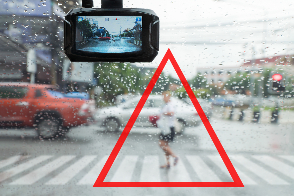Stylized image of a dashcam spotting a pedestrian in crosswalk