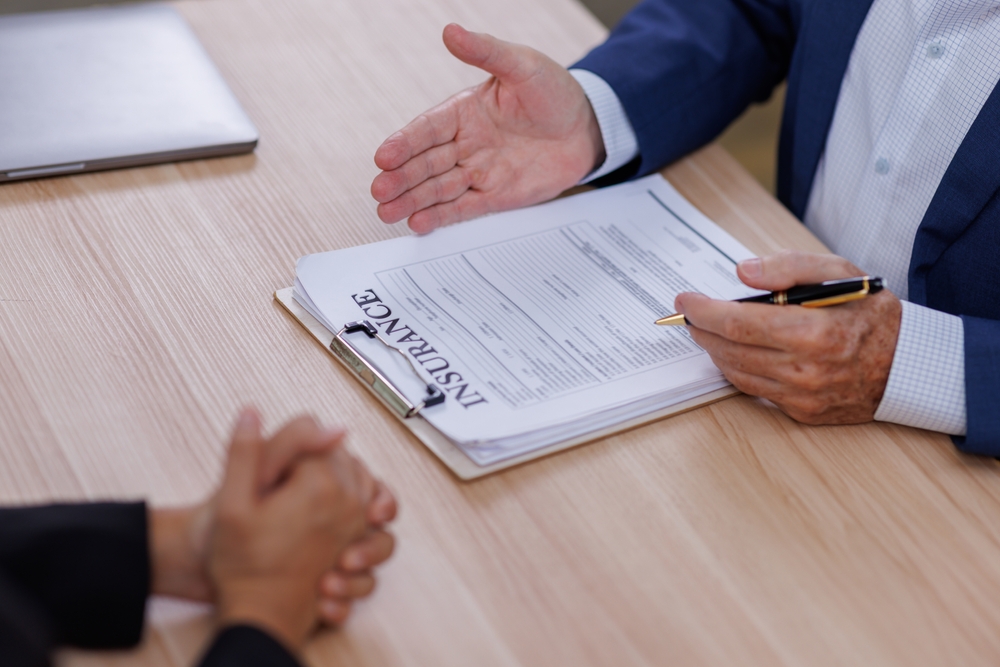 Client reviewing insurance contract with legal specialist